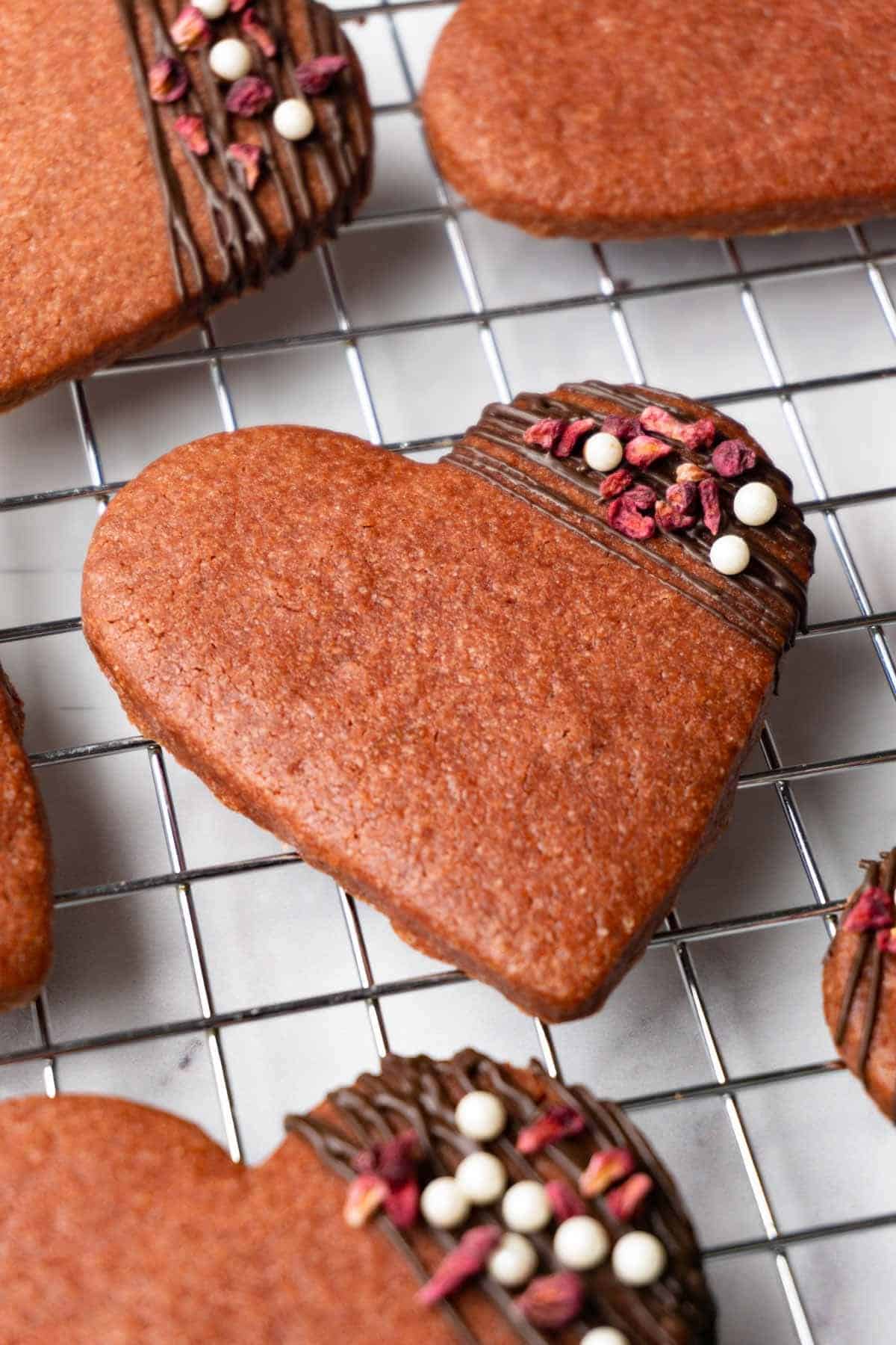 Chocolate cookies with a corner dipped in chocolate that is decorated with colored sprinkles.