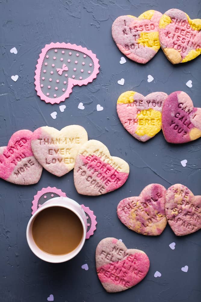 Multi colored heart cookies and a grey background.