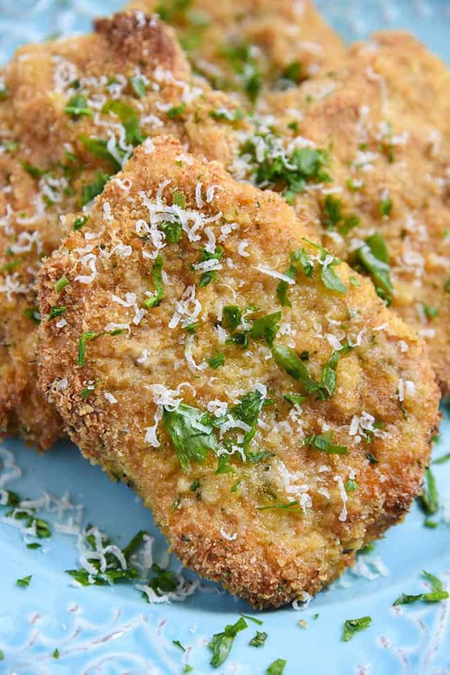 Parmesan crusted pork chops with parsley garnish.