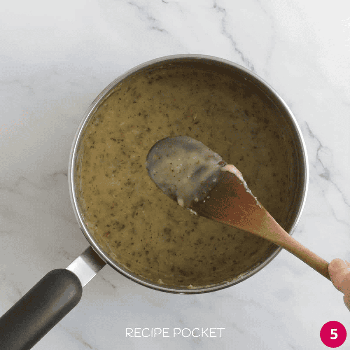 Sauce coating the back of a wooden spoon.
