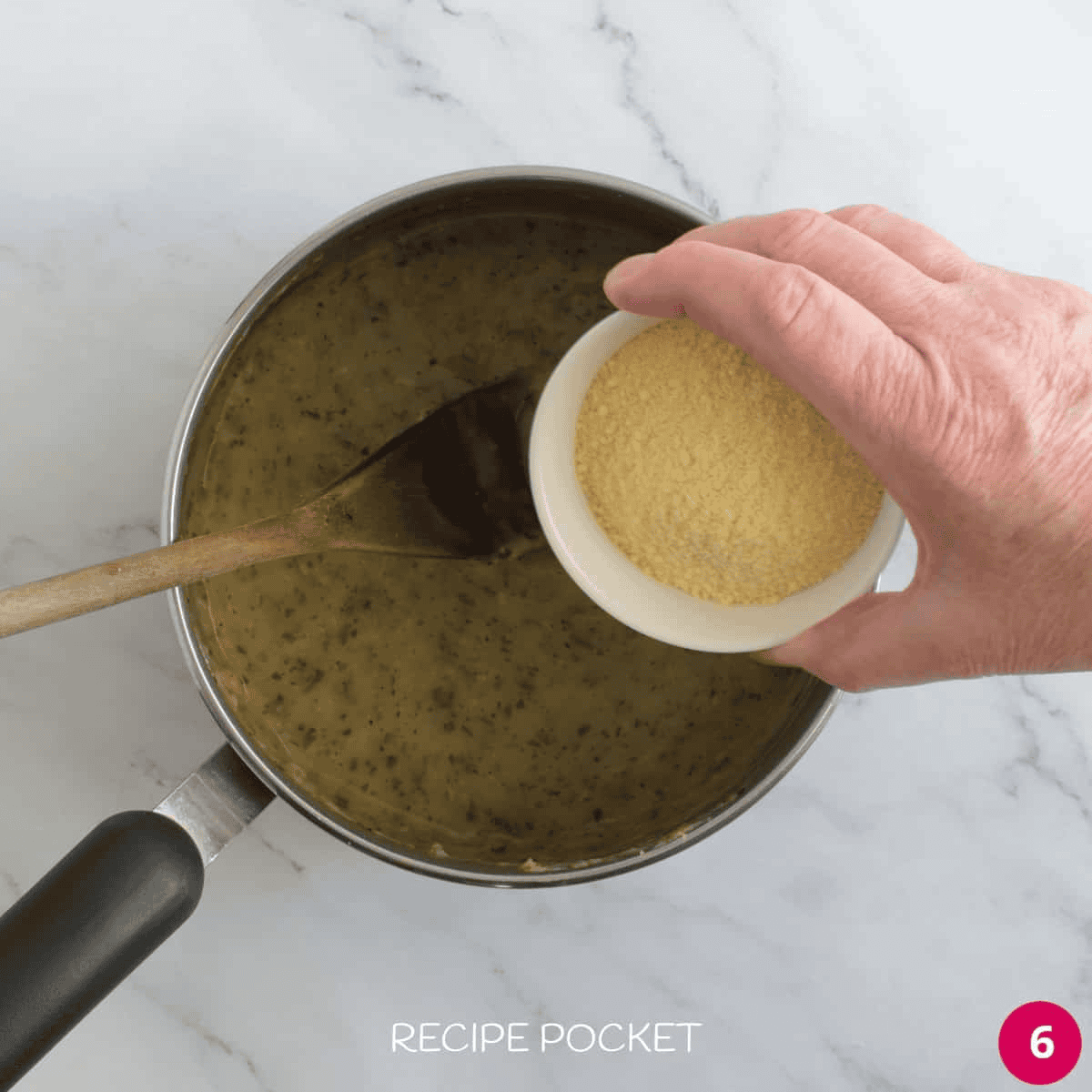 Grated parmesan cheese being added to a sauce.