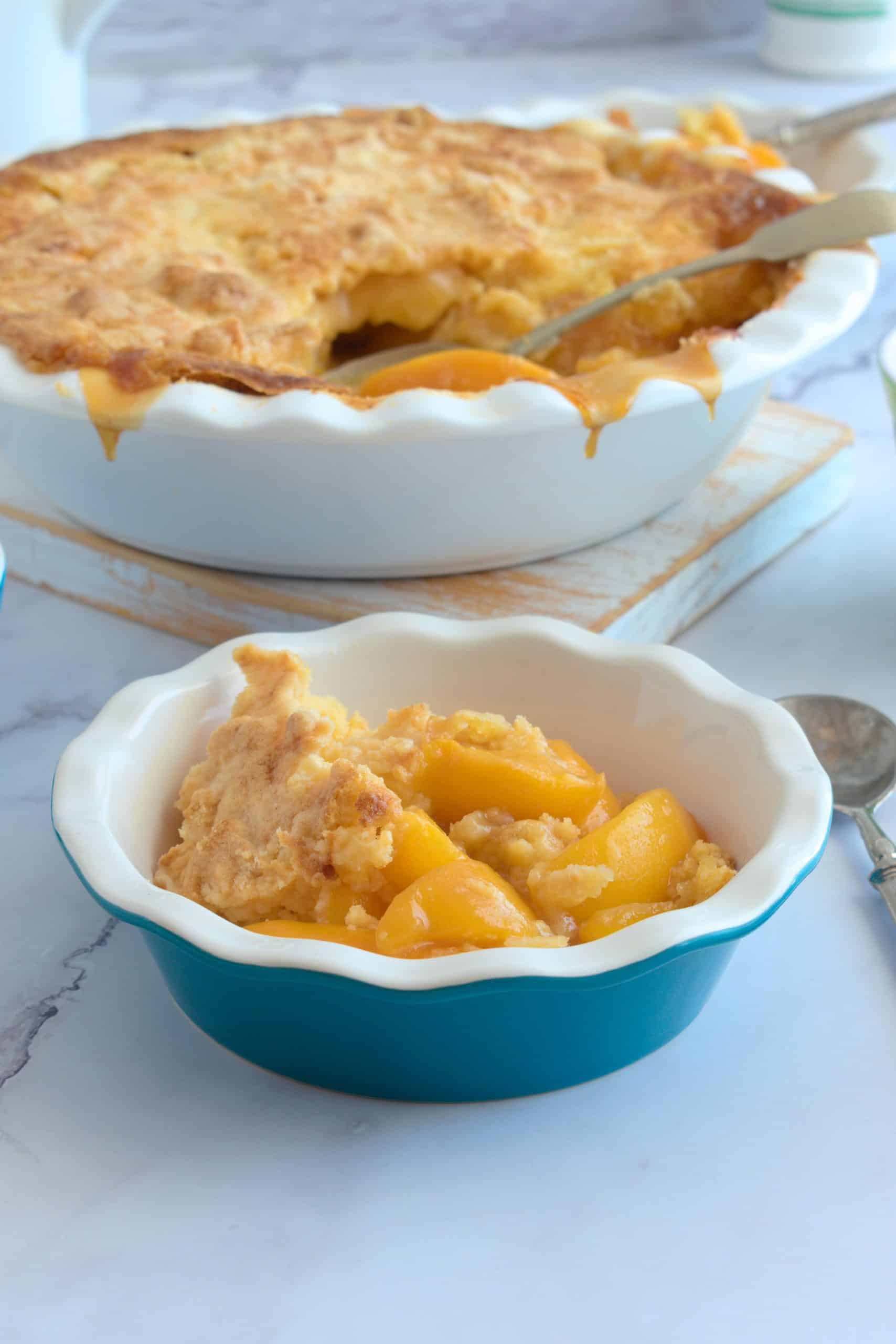 A blue bowl with peaches and a crumble topping.