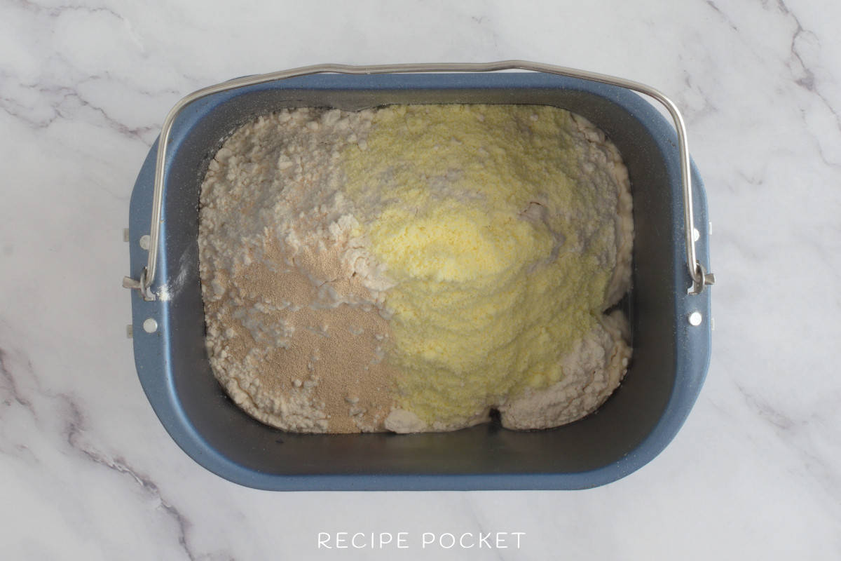 Ingredients for white bread in a bread machine pan.