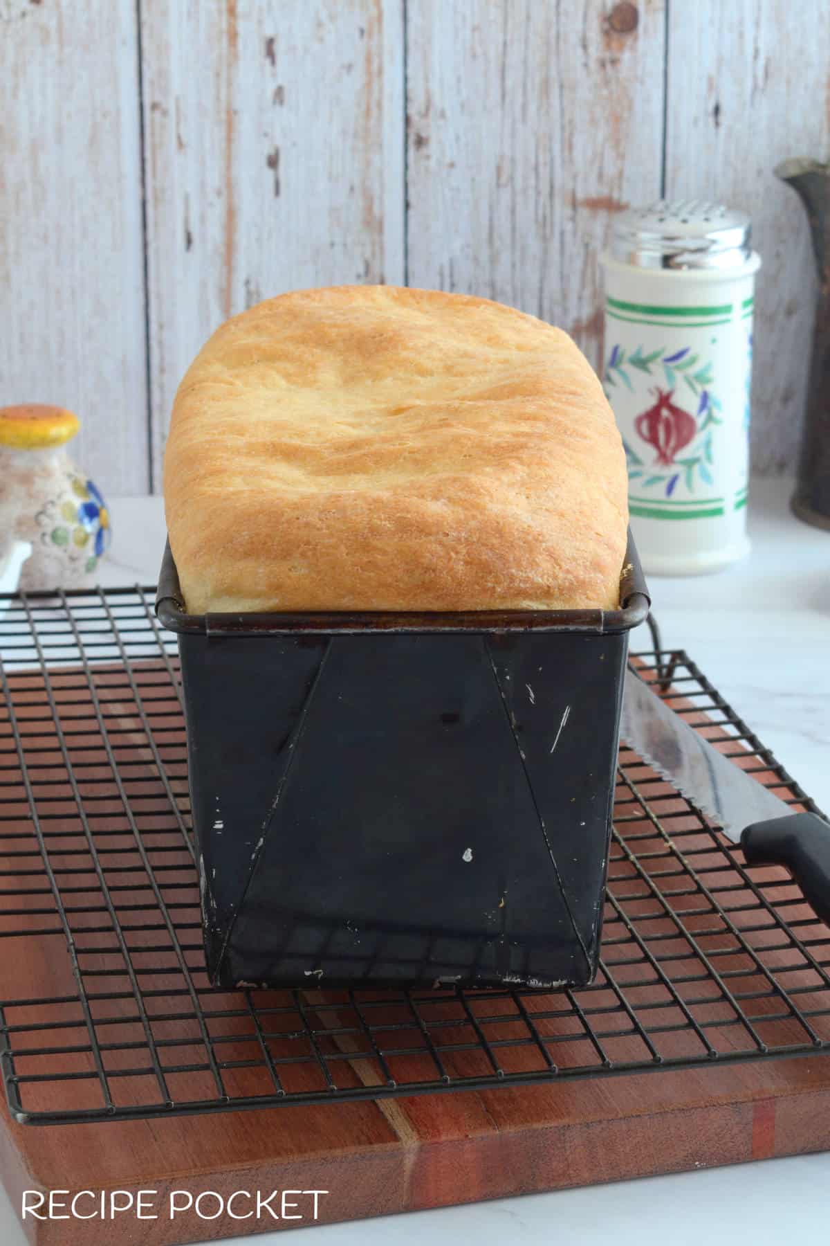 A loaf of baked bread in a bread tin.