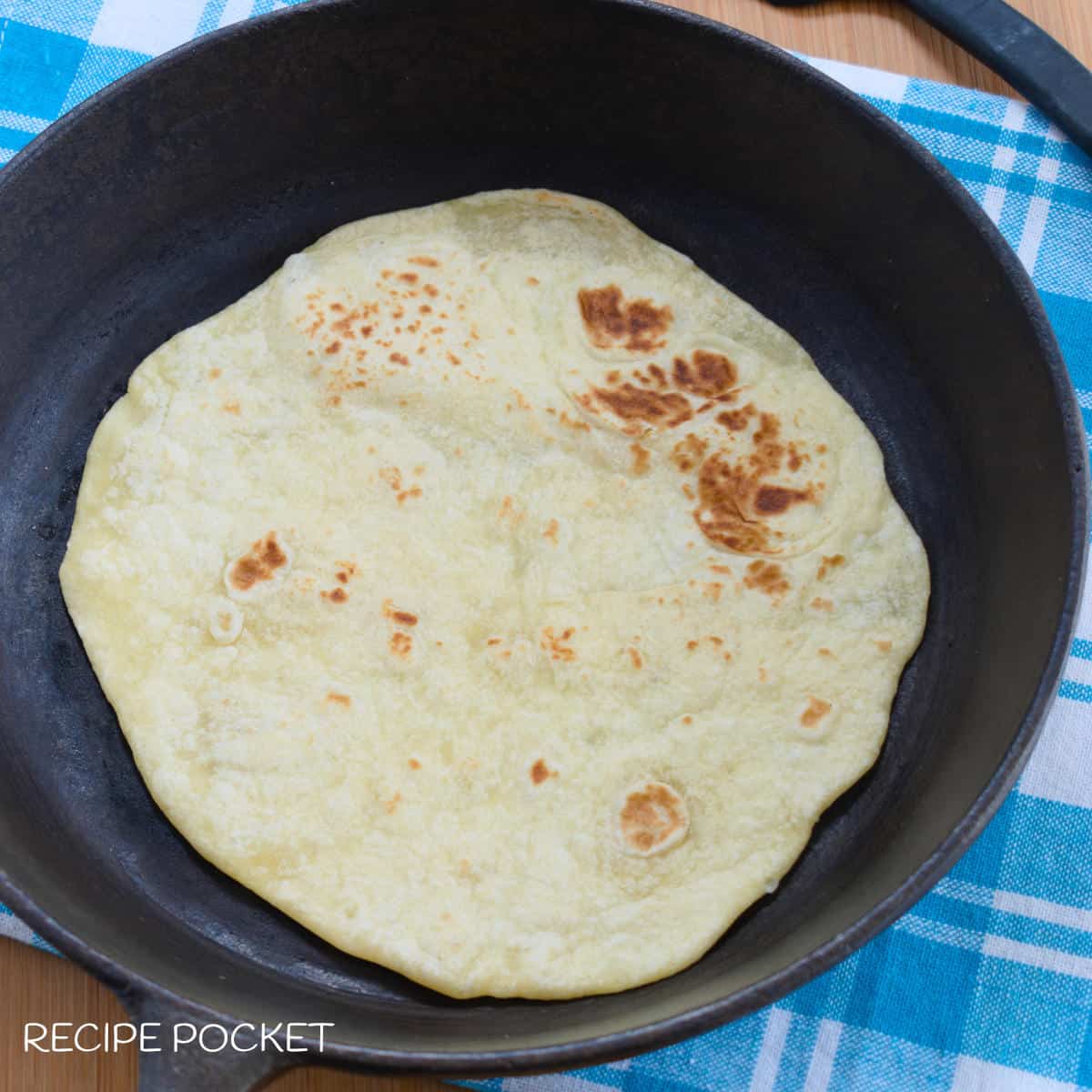 A cooked tortilla in a skillet.