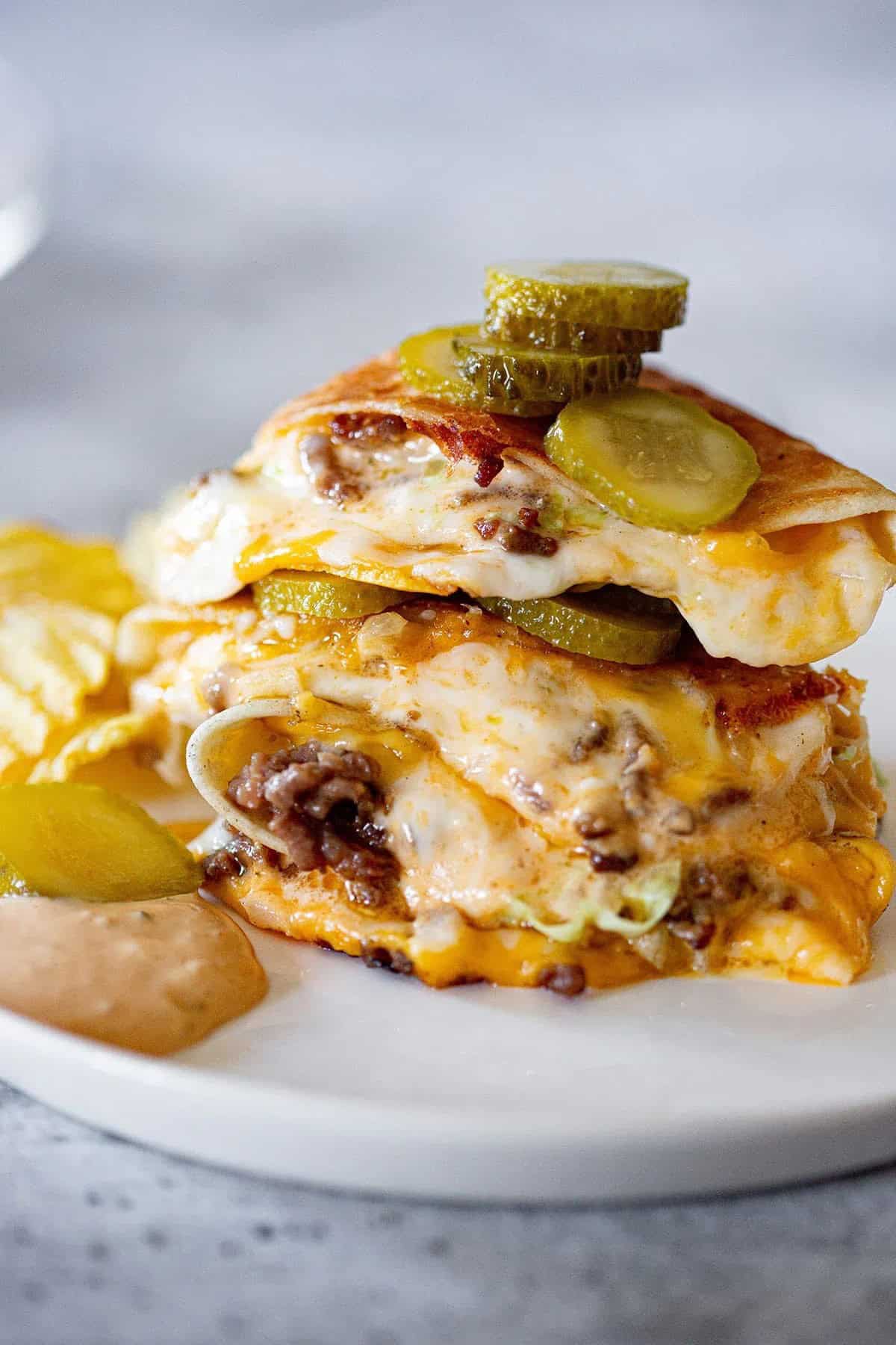 Two pieces of cheesy quesadilla on a plate.