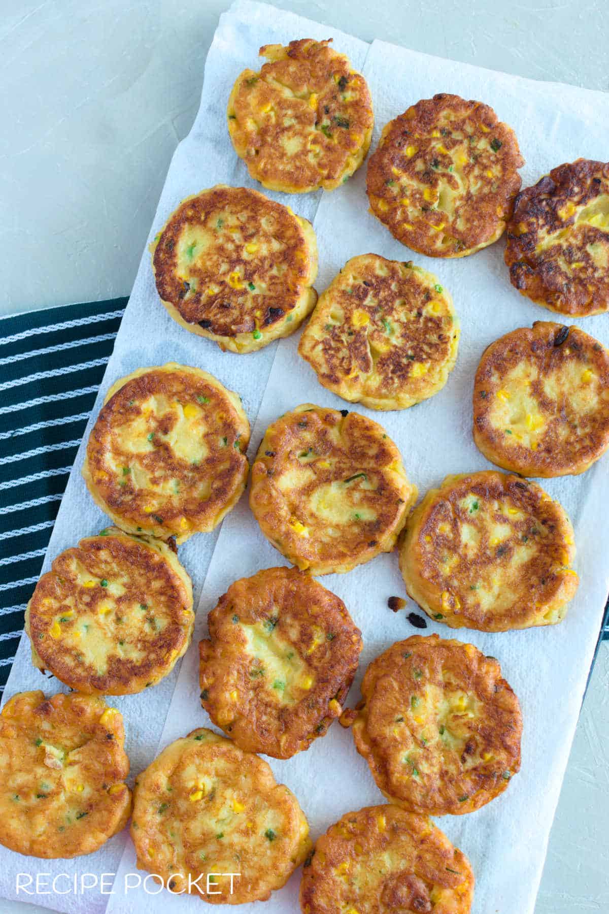 Cooked sweet corn fritters on paper towels.